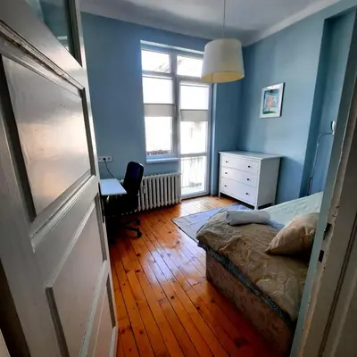 a bedroom with a bed and a desk and a window at Cozy & Stylish apartment in the heart of Sofia in Sofia