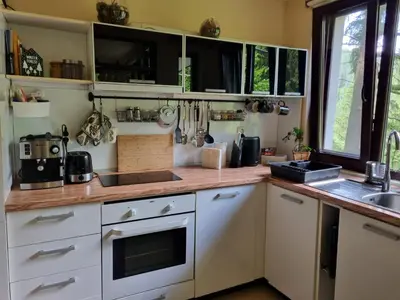 a kitchen with white cabinets and a wooden counter top at 