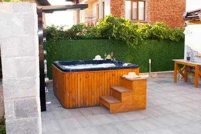 a jacuzzi tub in the middle of a patio at Ози 1 Допълнителна къща за гости in Ovchartsi