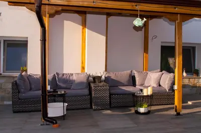 a outdoor patio with couches and pillows at Ози 1 Допълнителна къща за гости in Ovchartsi