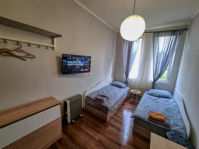 a bedroom with two beds and a tv on the wall at Charming Studio in Sofia Center in Sofia