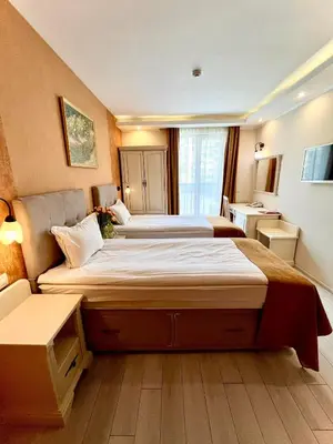 a hotel room with two beds and a couch at Hotel Adria in Sofia