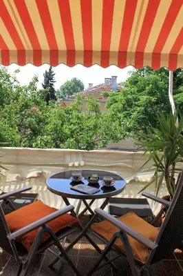 a table and chairs on a patio with an umbrella at Orange House in the Old Town Plovdiv- free parking in Plovdiv