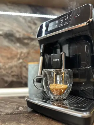 a cup of coffee is being poured into a coffee maker at Vitosha Terrace 1BR Apartment with Parking in Sofia
