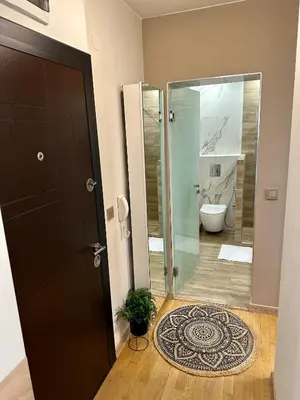 a bathroom with a toilet and a glass door at Vitosha Terrace 1BR Apartment with Parking in Sofia
