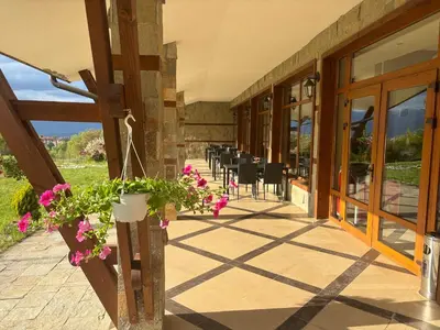 a patio with pink flowers in a pot on a building at Panorama Bansko in Bansko