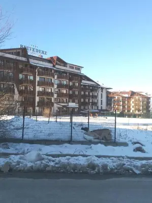 a fence in front of a building in the snow at Belvedere Holidey Clab apartament L403 in Bansko