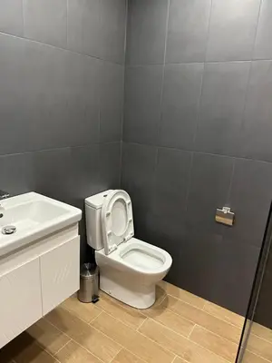 a bathroom with a white toilet and a sink at Lux apartments Top center in Sofia
