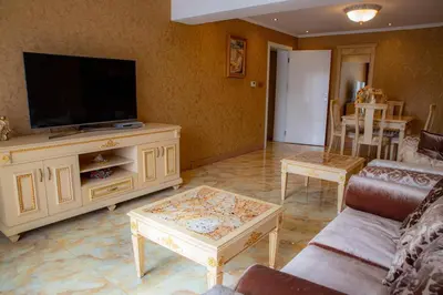 a living room with a tv and a couch and a table at Luxury Apartment 'Rich' in Velingrad