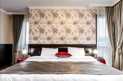 a bedroom with a large bed with a red pillow at Astrea Deluxe in Hisarya