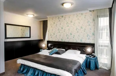 a bedroom with a large bed in a room at Astrea Deluxe in Hisarya