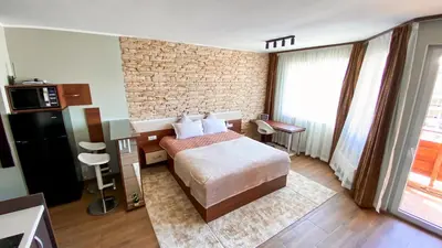 a hotel room with a bed and a brick wall at Deluxe Studio 200m from Ski Road in Bansko