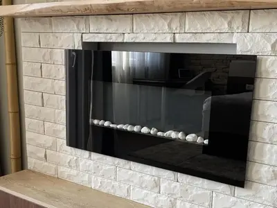 a stone fireplace with a tv in it at Deluxe Studio 200m from Ski Road in Bansko