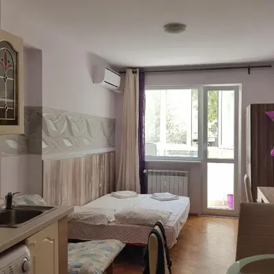 a bedroom with two beds and a sink and a window at Studio Rositza in Sofia
