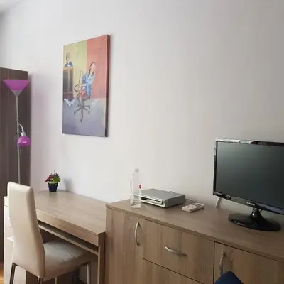 a desk with a television on top of a wooden cabinet at Studio Rositza in Sofia
