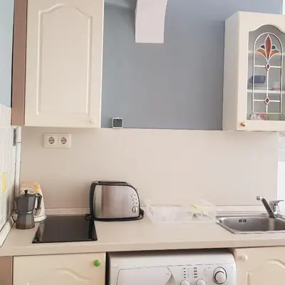 a small kitchen with white cabinets and a sink at Studio Rositza in Sofia