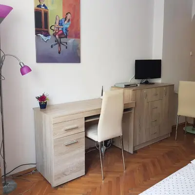 a wooden desk with two chairs and a television at Studio Rositza in Sofia