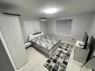a bedroom with a bed and a television in it at Еделвайс Edelvais in Kostenets Village