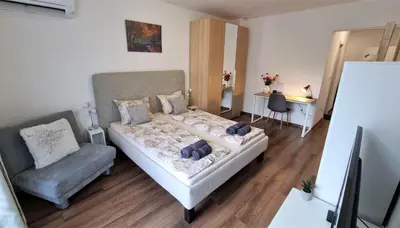 a small bedroom with a bed and a chair at Luxury Quiet Apartment in the City Center in Plovdiv