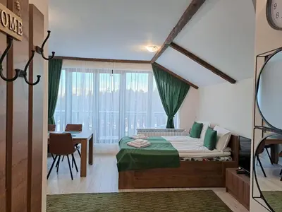 a bedroom with a bed and a table and a window at Large studio with view in Borovets Gardens in Borovets