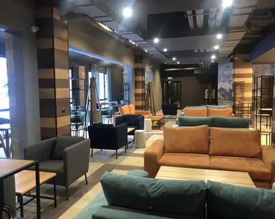 a living room with couches and tables and chairs at Large studio with view in Borovets Gardens in Borovets