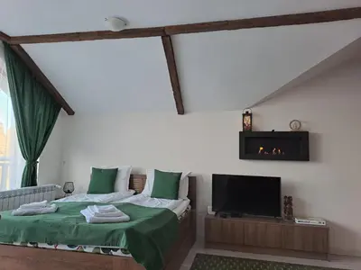 a bedroom with a bed and a flat screen tv at Large studio with view in Borovets Gardens in Borovets