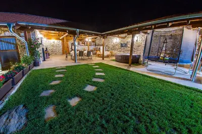 a yard with stepping stones on the grass at night at Къща за приятели Недкови in Vasil Levski