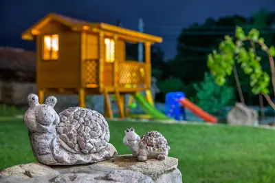 a statue of two turtles sitting on a rock with a playground at Къща за приятели Недкови in Vasil Levski