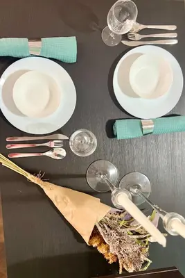 a table with white plates and glasses and utensils at Flower house 8 in Sofia