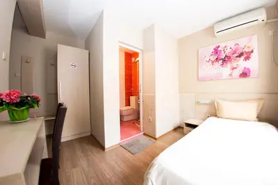 a bedroom with a bed and a bathroom at Family Hotel Madrid in Sofia