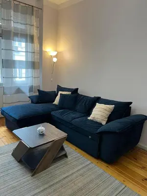 a blue couch in a living room with a table at CityPulse Apt in Ideal Center w Working Space in Sofia