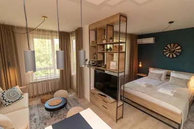 a bedroom with a bed and a living room at Heart of Sofia Studio in Sofia