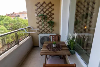 a small balcony with a wooden table and chairs at Heart of Sofia Studio in Sofia
