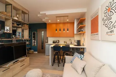 a living room with a couch and a kitchen at Heart of Sofia Studio in Sofia