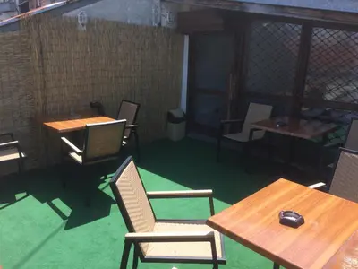 a room with wooden tables and chairs and green carpet at 4 Rooms in Plovdiv