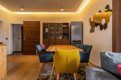a dining room with a wooden table and blue chairs at The Honeycomb Hideaway by Flat Mаnager in Sofia