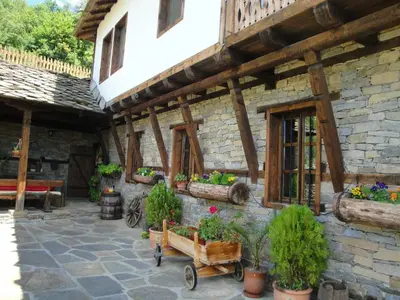 a stone house with potted plants on the side of it at Leshten Valentin's House in Leshten