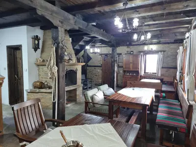 a living room with wooden tables and chairs and a fireplace at Leshten Valentin's House in Leshten