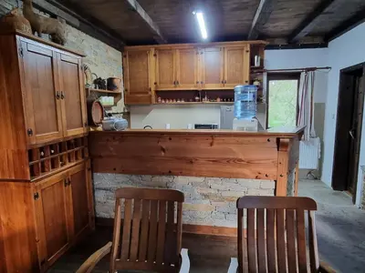 a kitchen with wooden cabinets and two chairs at Leshten Valentin's House in Leshten
