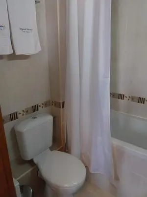 a bathroom with a toilet and a shower curtain at Piringolf apartment in Razlog