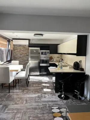 a kitchen and dining room with a table and chairs at Guest House EGO in Bratsigovo