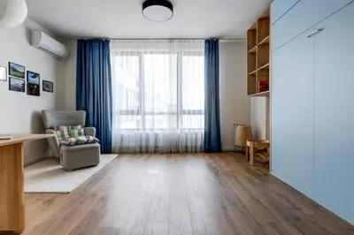an empty living room with a chair and a window at New Studio - 300m Subway - 10 Mins City Centre in Sofia