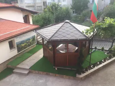 a small gazebo in a yard with grass at Белевската къща с беседка Belevska House with gazebo in Smolyan