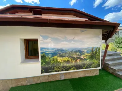a mural on the side of a house with green grass at Белевската къща с беседка Belevska House with gazebo in Smolyan