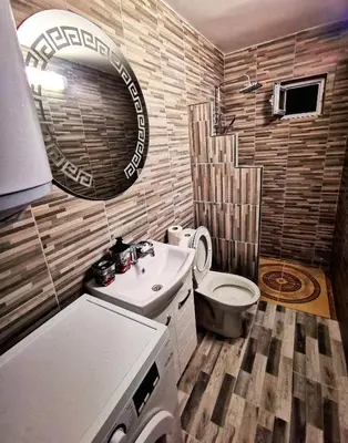 a bathroom with a toilet and a sink and a mirror at Студио за гости - Лили in Ognyanovo