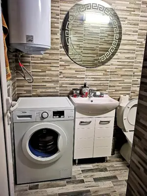 a bathroom with a washing machine and a sink at Студио за гости - Лили in Ognyanovo