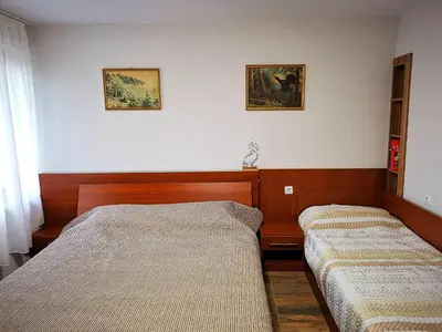 a bedroom with two beds and two pictures on the wall at Студио за гости - Лили in Ognyanovo