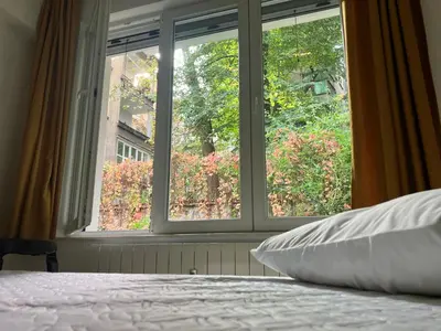 a bedroom with a window looking out at a garden at Opera Flat in Sofia