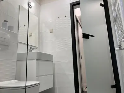 a bathroom with a toilet and a glass shower at Opera Flat in Sofia