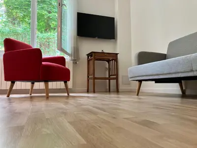 a living room with two chairs and a flat screen tv at Opera Flat in Sofia